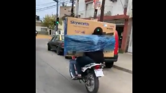 Embalados y virales: se atan una TV y un lavarropas para transportarlos en moto
