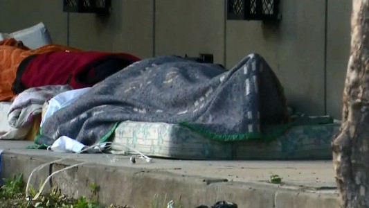 Personas en situación de calle duermen bajo el alero de una escuela en zona sur