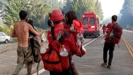La foto viral que conmueve: el héroe que rescató a una nena en medio de los incendios del sur
