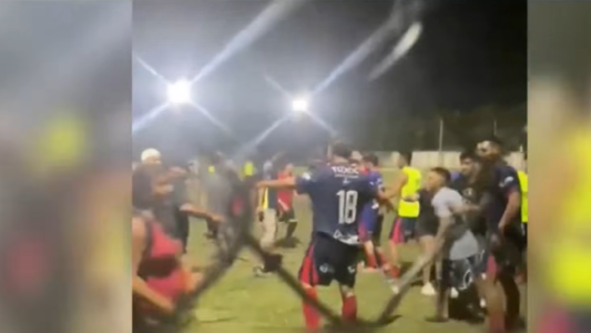 Jugadores y público enfrentados en un partido de fútbol amateur