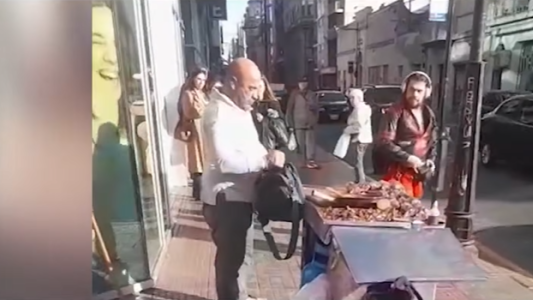 Un peatón y un vendedor ambulante a las piñas en el centro