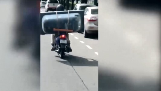 En moto y con una bañera a cuestas por plena costanera