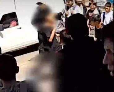 A las piñas en la puerta de la escuela